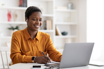 Cheerful african american woman student having online class at home