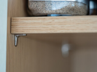 selected focus close up of a kitchen cabinet  chromed steel shelf support bracket pin
