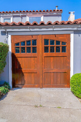 Side-hinged wooden garage door with glass window panels at San Francisco, California
