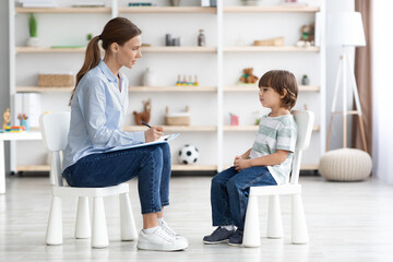 Psychological consultation for kids. Side view shot of professional woman psychotherapist sitting...