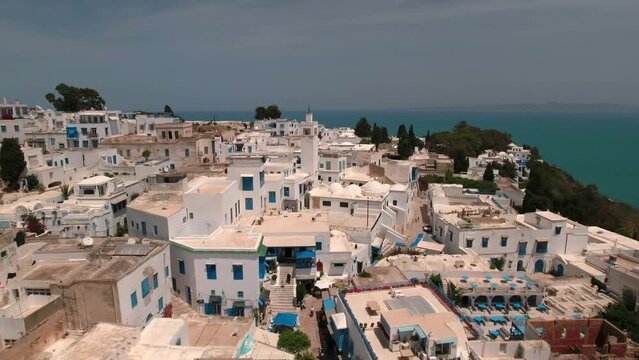 Aerial Backward Beautiful Shot Of Mosque Amidst White Buildings On Town Hill - Djerba, Tunisia