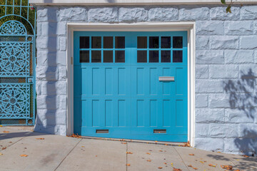 Sky blue side-hinged garage doors with window panels and letter box in San Francisco, California
