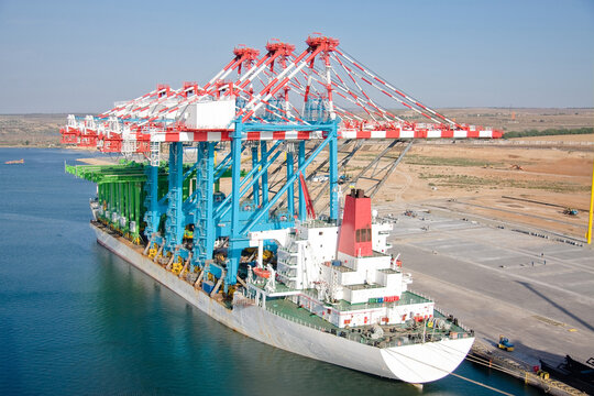 Unloading of cranes on the berth. Vessel at the berth with new berthing and rear container cranes STS and RTG