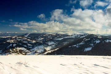Slavske ski slope with blue sky surrounded by mountains and forests. Carpathian Mountains, Ukraine. 
