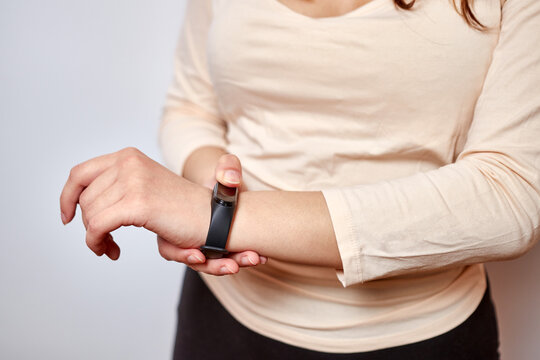 The girl puts on a fitness bracelet. Modern gadgets and digital technologies in human life.