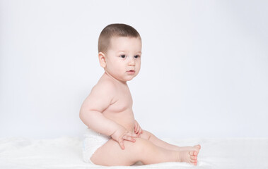 Cute smiling baby sitting on a blanket. Isolated over white.