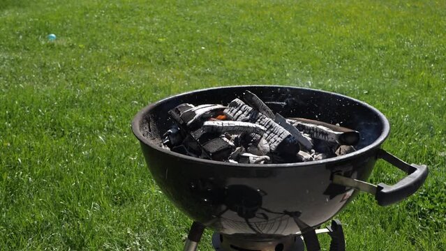 Barbeque grill heating up with charcoals on a suny day