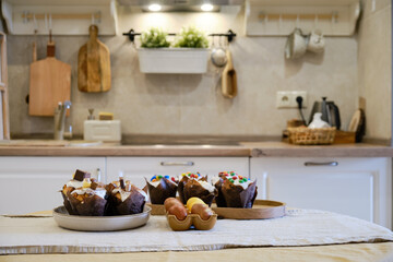 Easter cakes with chocolate ornaments and painted eggs on the table in the home kitchen