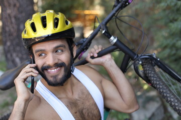Man holding mountain bike off road making a phone call
