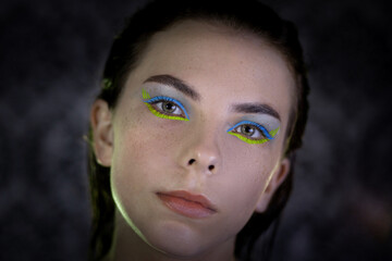 
portrait of a Ukrainian girl in the dark with make-up in the colors of the Ukrainian flag