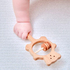 Baby hand and toy rattle abacus, close-up. Children fingers and an object on a white background