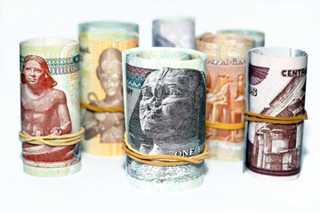 Egypt money roll pounds banknotes isolated on white background, Egyptian pounds cash money bills rolled up with rubber bands of 200 LE, 100, 50, 20, 10, 5, 1 pound and 50 piasters, selective focus