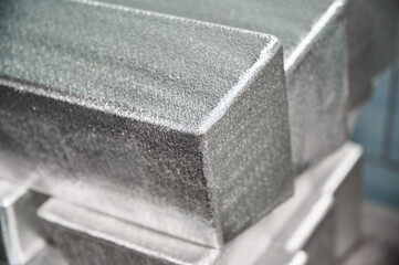 Pile of industrial silver bars at bright light in storage