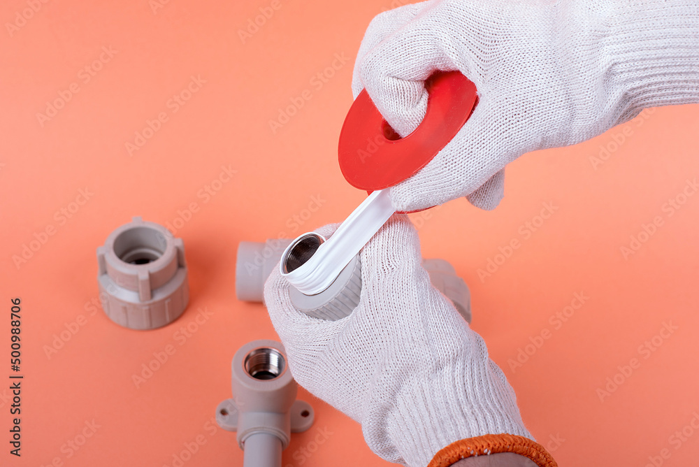 Wall mural hands of a plumber hold a plastic pipe on the background. fixing and installation of plumbing