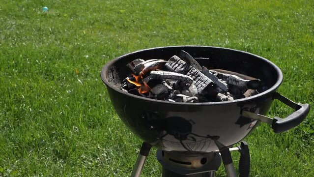 Barbeque grill heating up with charcoals on a suny day