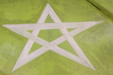 White pentagram star against green background painted on a boat at Ubatuba, Brazil
