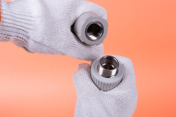 hands of a plumber hold a plastic pipe on the background. fixing and installation of plumbing