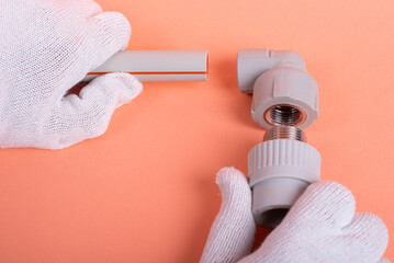 hands of a plumber hold a plastic pipe on the background. fixing and installation of plumbing