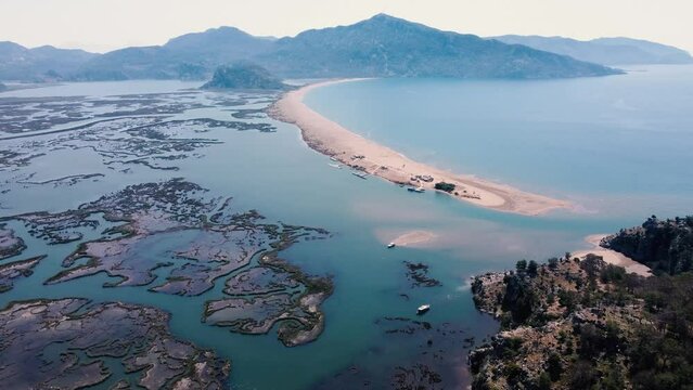 Aerial Survay Over the River Dalyan. Iztuzu Sand Spit Separates the River and the Sea. Tourist Boat Sailing on the River. Birds Eye View 4k