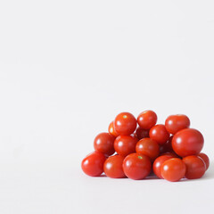 Bunch of fresh vegetables - red cherry tomatoes on a white background. Square. Copy space