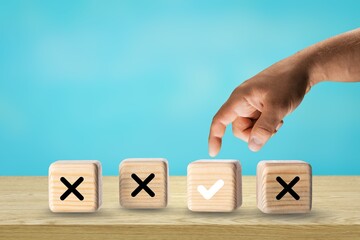 Quiz answer and poll concept. Check mark on wooden toy block stacked with cross symbol for true or...