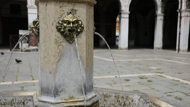 Fountain with a human like face gushing out fresh drinking water in the island of Venice