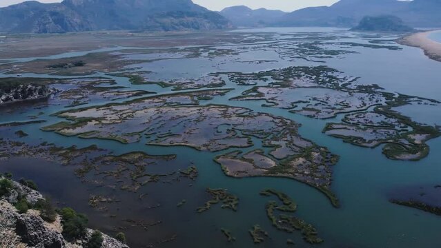 Aerial Survay Over the River Dalyan. Iztuzu Sand Spit Separates the River and the Sea. Tourist Boat Sailing on the River. Birds Eye View 4k