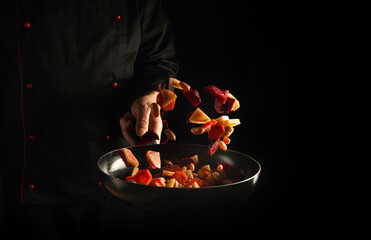 The chef prepares fresh vegetables in a frying pan. Space for advertising a hotel or restaurant