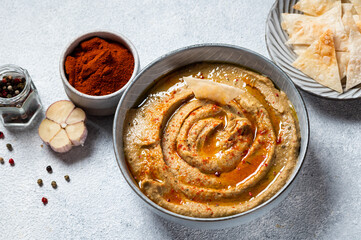 Traditional arabian eggplant dip baba ganoush with herbs and smoked paprika on light background. Eggplant hummus. Babaganush or eggplant caviar. Baked eggplant. Turkish eggplant dip