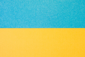 Textured two-tone paper background in yellow and blue. Dual background, flat lay. High quality photo