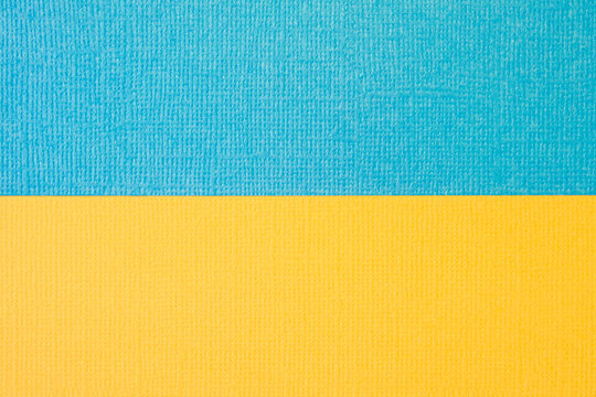 Textured two-tone paper background in yellow and blue. Dual background, flat lay. High quality photo