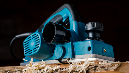 Manual electric plane on an untreated log of a tree. Wooden products. Production of wood products.