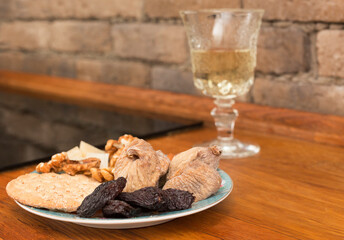 Dried fruits and a glass of white wine on a wooden table..Close-up. Selective focus.