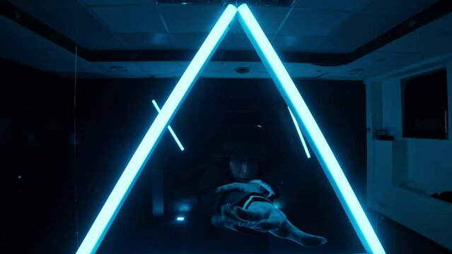 Stylish woman dancing indoors with smoke and neon light. Youth culture. Triangle neon shape. Hiphop. Young female in suit dancing. Slow motion in 4K, UHD