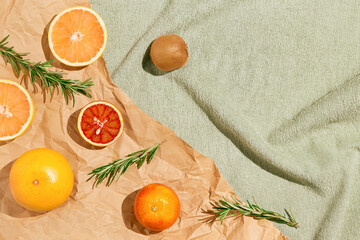 Creative summer scene with fruits,rosemary on craft paper and pastel green beach towel. Refreshment...