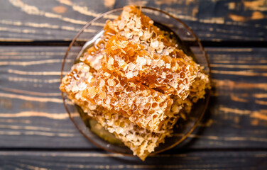 honey in honeycombs on a brown wooden background
