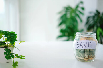 Glass jar with dollars and text: save. Money saving concept. Credit. Copy space.