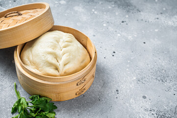 Pyanse steamed bun in a Bamboo steamer, korean street food. Gray background. Top view. Copy space