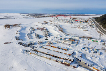 Khanty-Mansiysk in winter. The Irtysh River and berths. The Red Dragon Bridge. Aerial view.