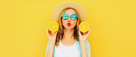 Summer portrait of happy young woman blowing her lips with slices of fresh orange fruits wearing...