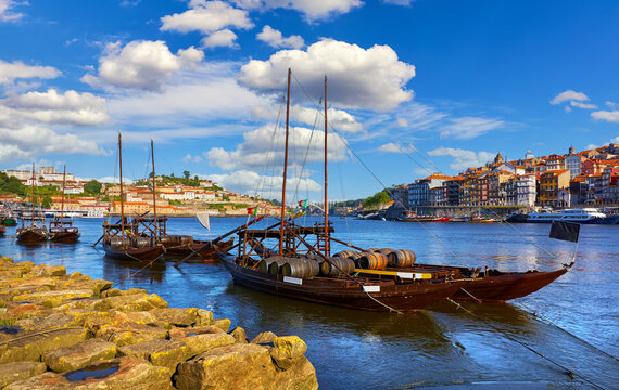 Porto Portugal. Vintage boat with barrel port and wine at coast river Douro. Old town with authentic architecture. Picturesque landscape.
