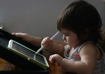 Mother with her daughter drawing on digital drawing tablet