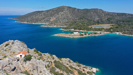 Obraz premium Aerial drone photo of small island of Dorousa and small chapel of Profitis Ilias built uphill next to famous Aponisos bay, Agistri island, Greece