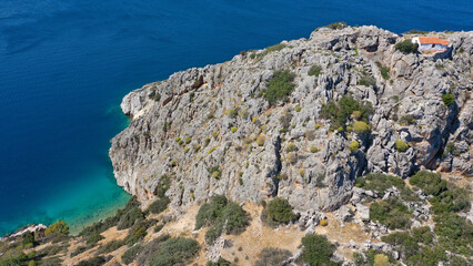 Fototapeta premium Aerial drone photo of small island of Dorousa and small chapel of Profitis Ilias built uphill next to famous Aponisos bay, Agistri island, Greece