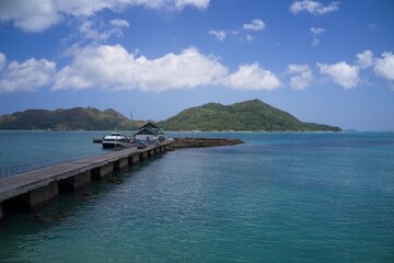 Drone field of view of jetty leading into  harbour with islands in background in Praslin, Seychelles.