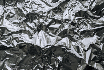 Background, texture of silver shiny foil, colored crumpled paper. Photo, top view, copy space.