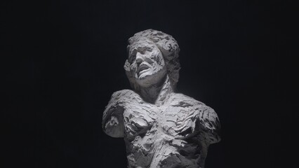 A white statue of a man. A close-up shot on a black background.