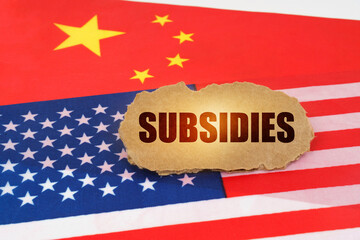 On the flags of the USA and China lies a cardboard sign with the inscription - Subsidies