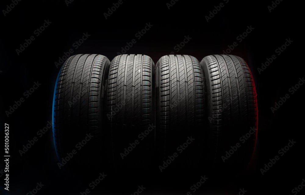 Wall mural new car tires. group of road wheels on dark background. summer tires with asymmetric tread design. d