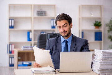 Obraz premium Young male employee and too much work in the office